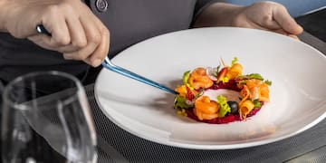 a person holding a fork over a plate of food