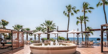a water fountain with umbrellas and chairs on a patio