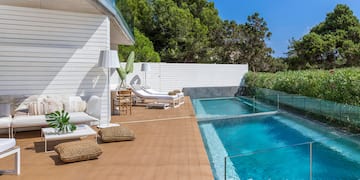 a swimming pool and a deck with chairs