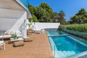 a swimming pool and a deck with chairs