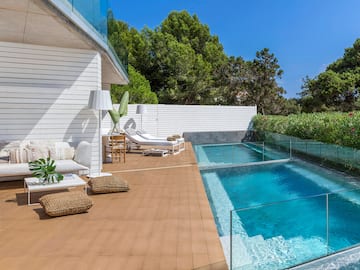 a swimming pool and a deck with chairs