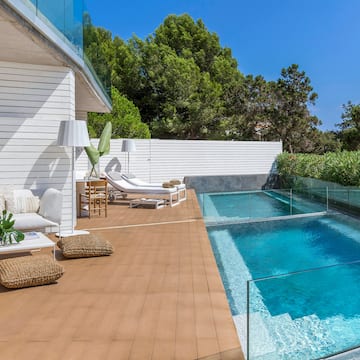 a swimming pool and a deck with chairs