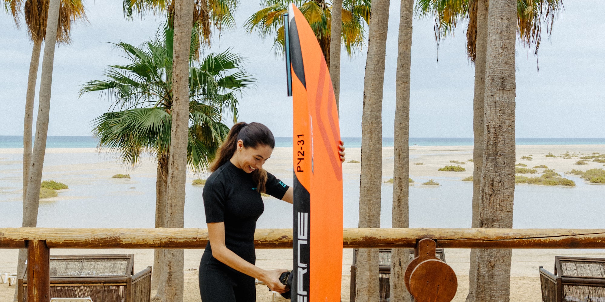 a woman standing next to a surfboard