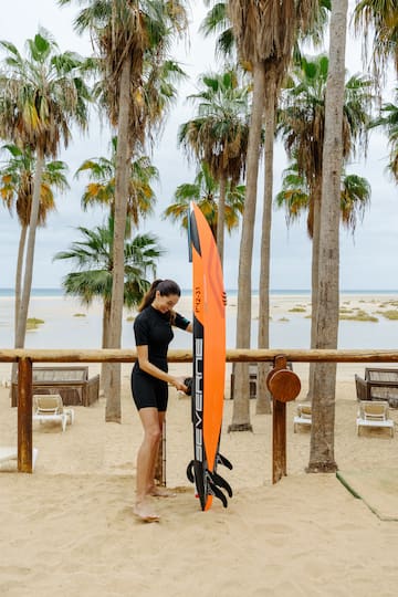 a woman standing next to a surfboard