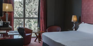 a room with a bed and chairs