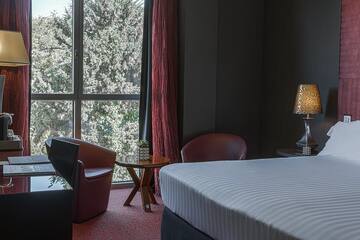 a room with a bed and chairs