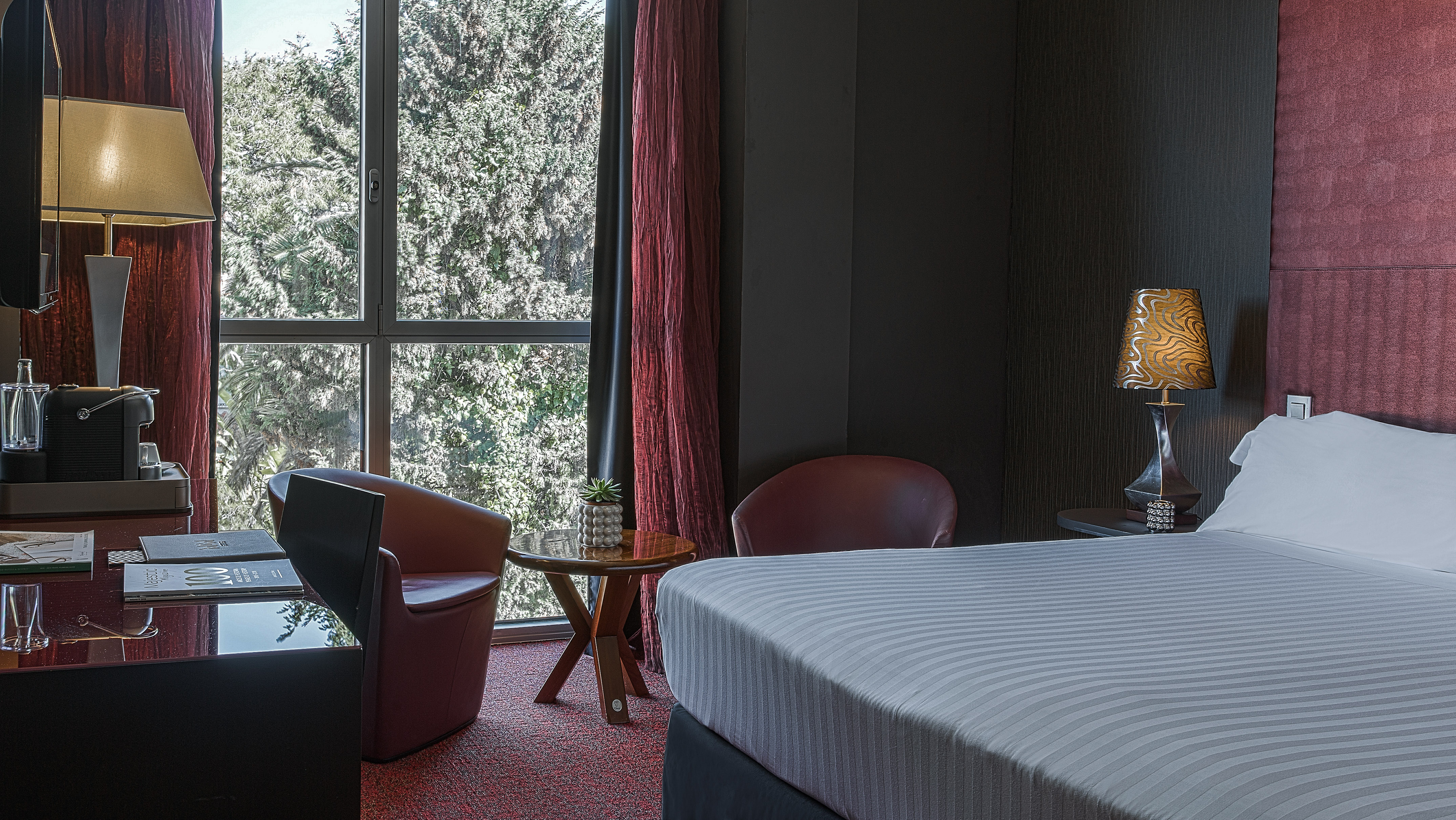 a room with a bed and chairs