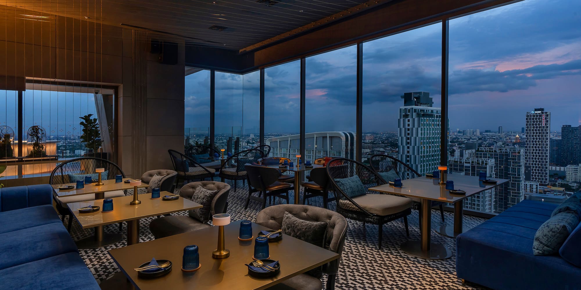 a room with tables and chairs and a view of a city