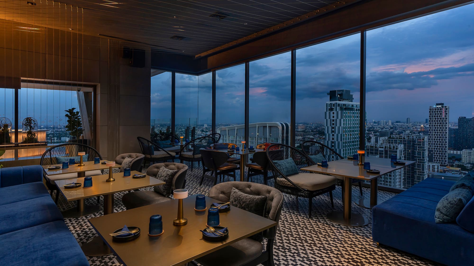 a room with tables and chairs and a view of a city