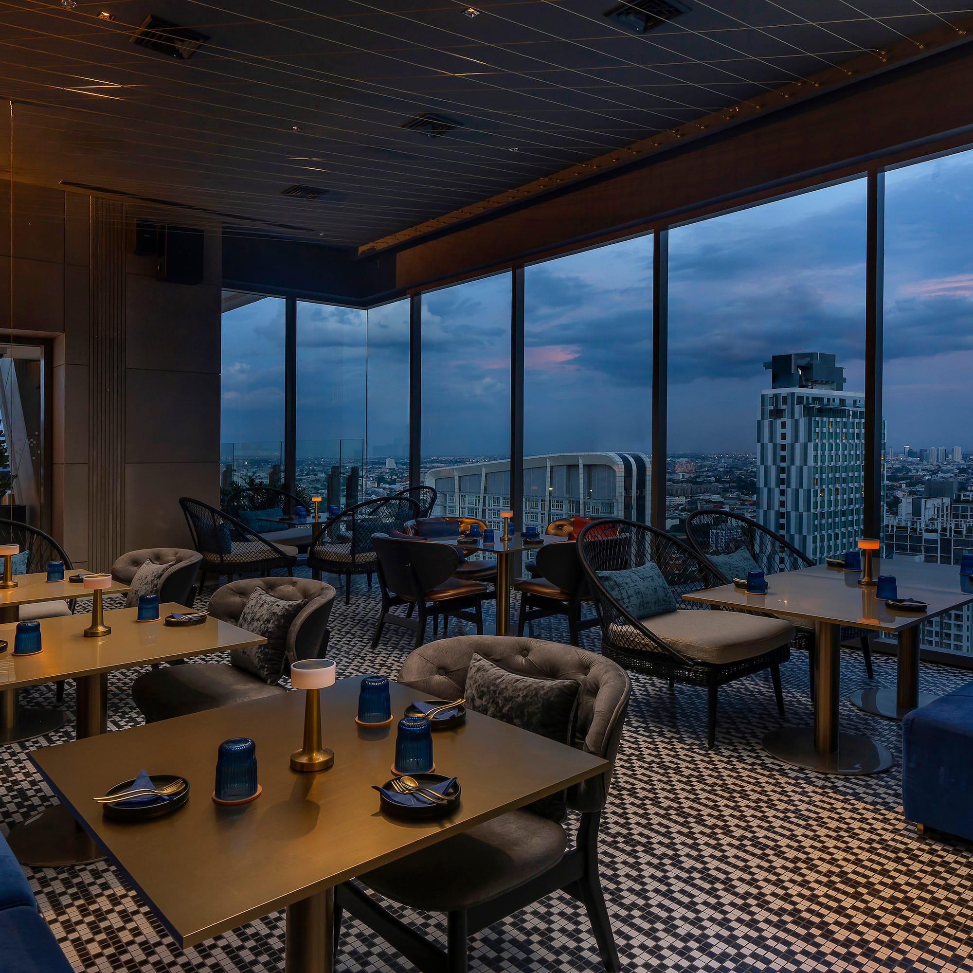 a room with tables and chairs and a view of a city