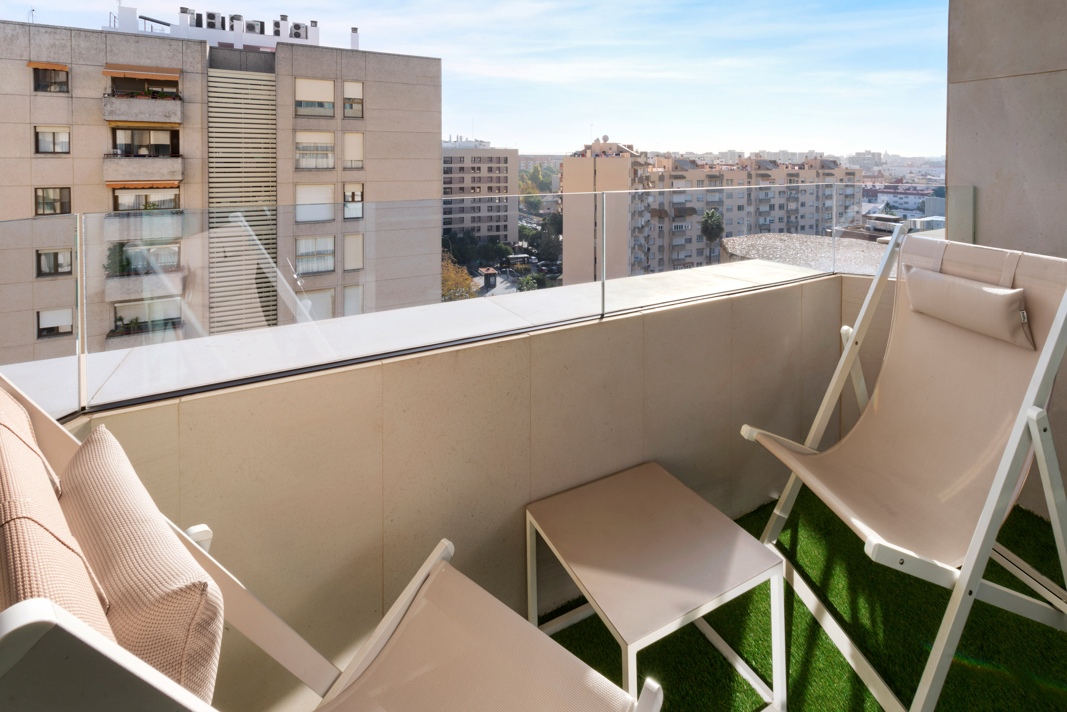 a balcony with chairs and a view of a city