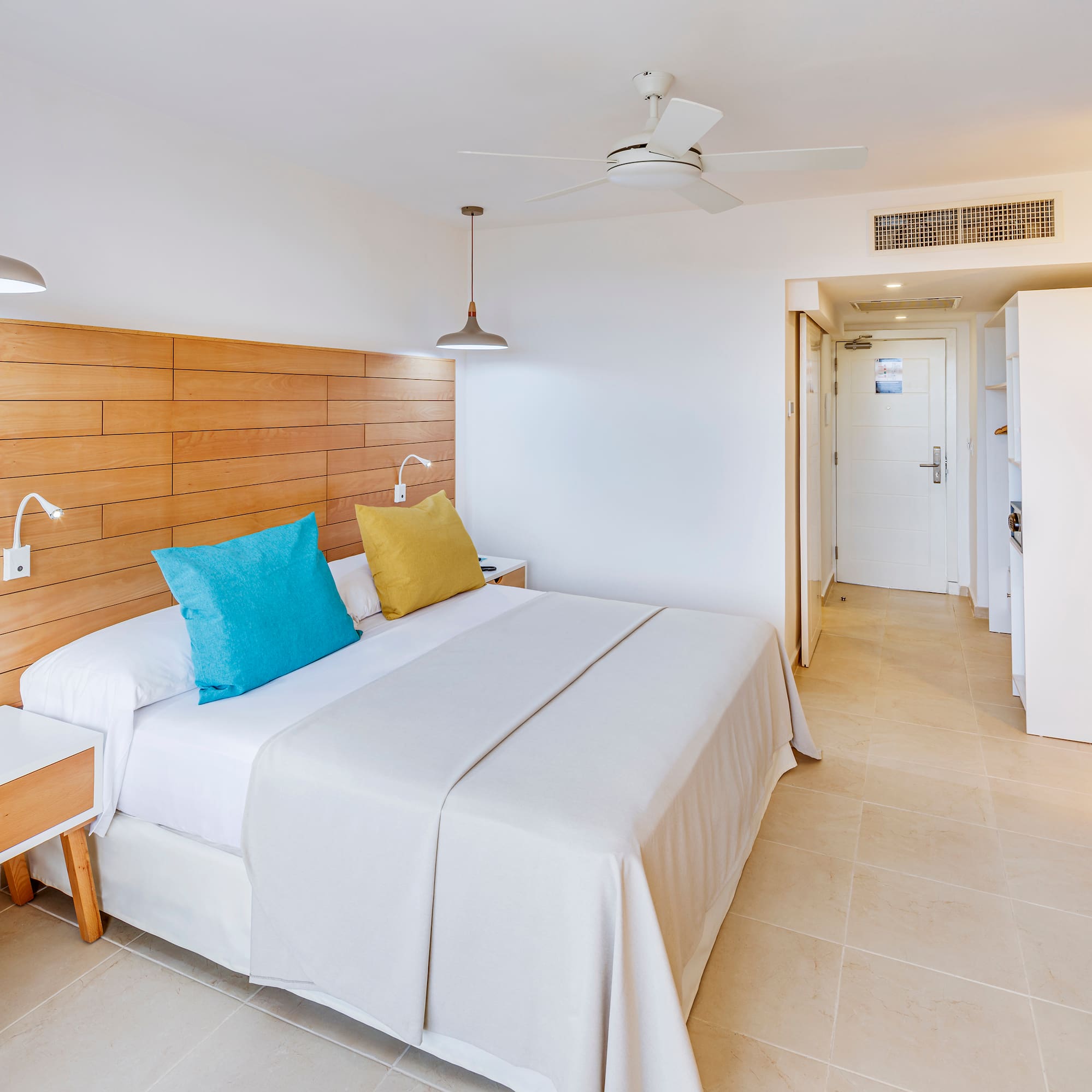 a bed with a wood headboard and a ceiling fan