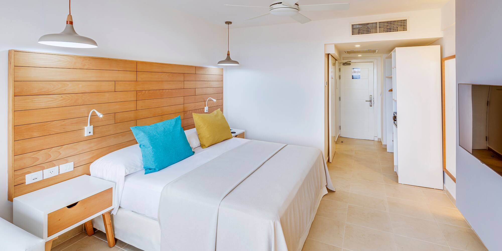 a bed with a wood headboard and a ceiling fan