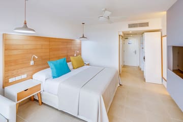 a bed with a wood headboard and a ceiling fan
