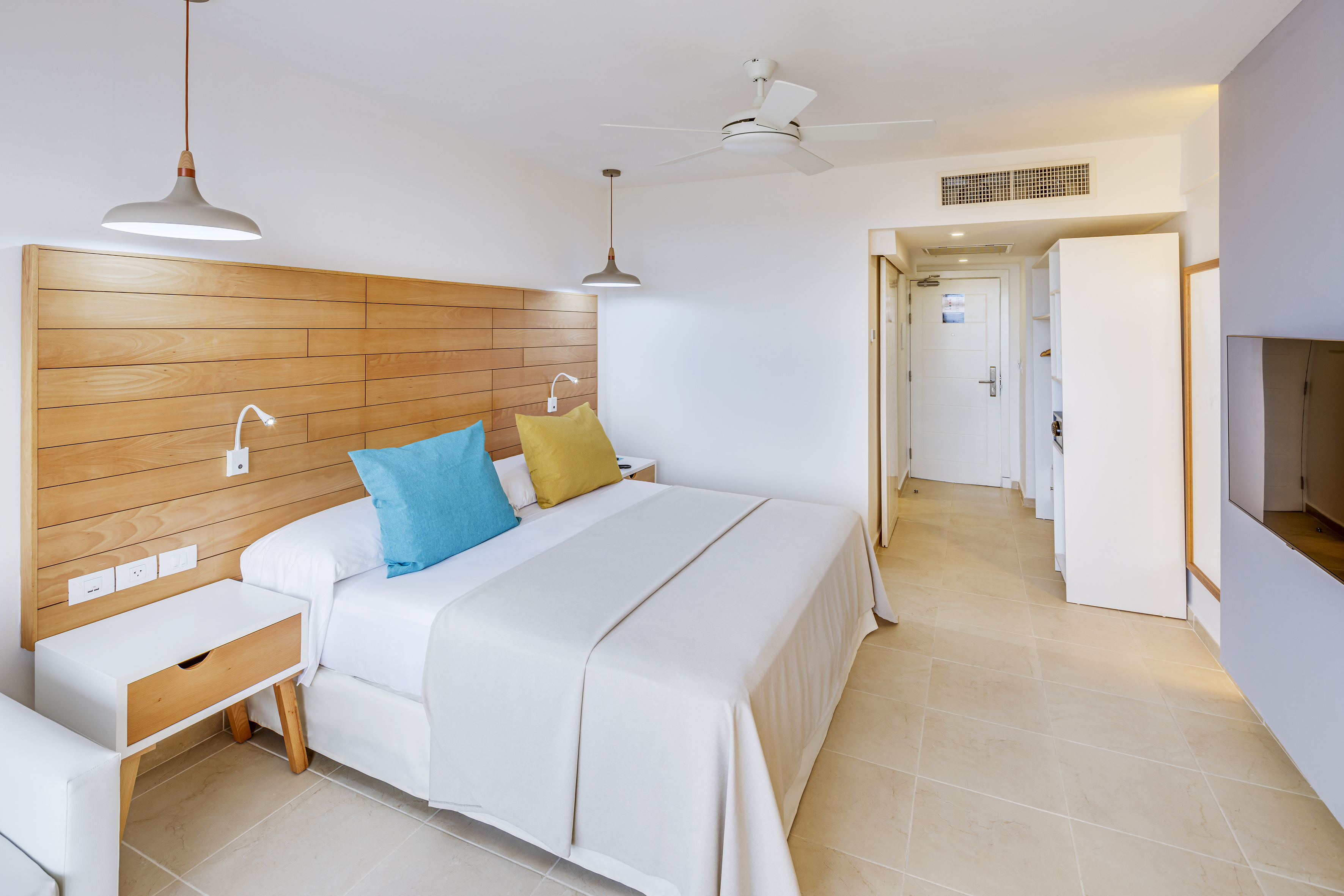 a bed with a wood headboard and a ceiling fan