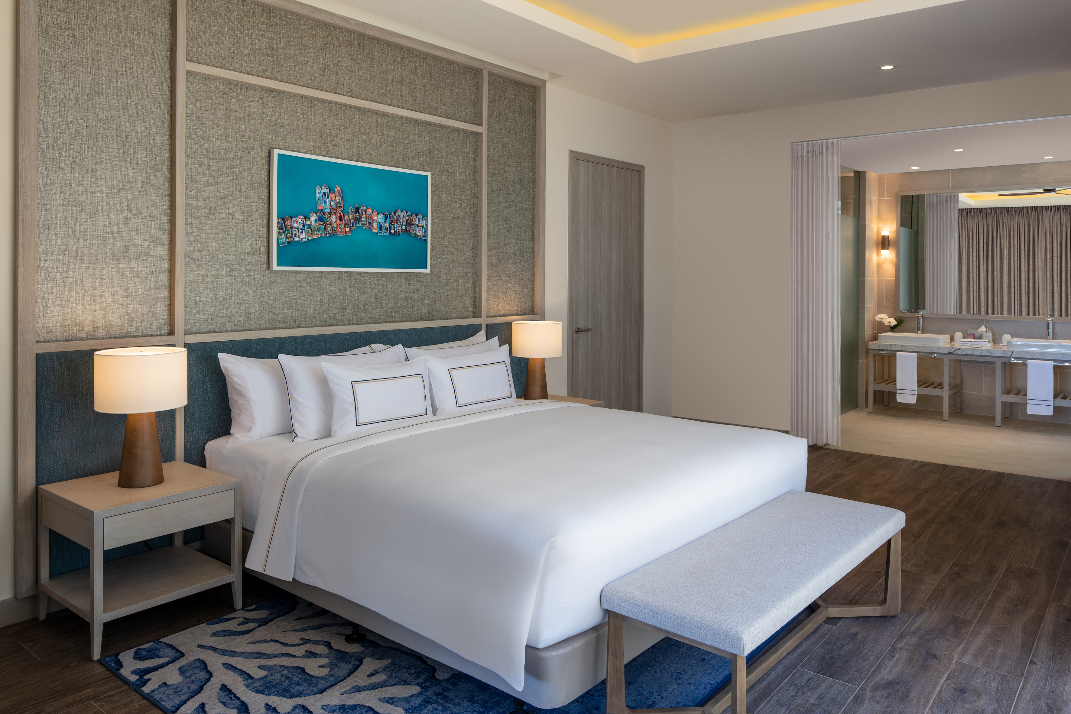 Luxurious king bed hotel room with modern decor and adjacent bathroom.