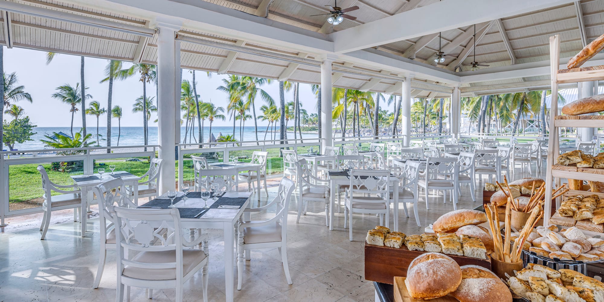 a room with tables and chairs and a table with food on it