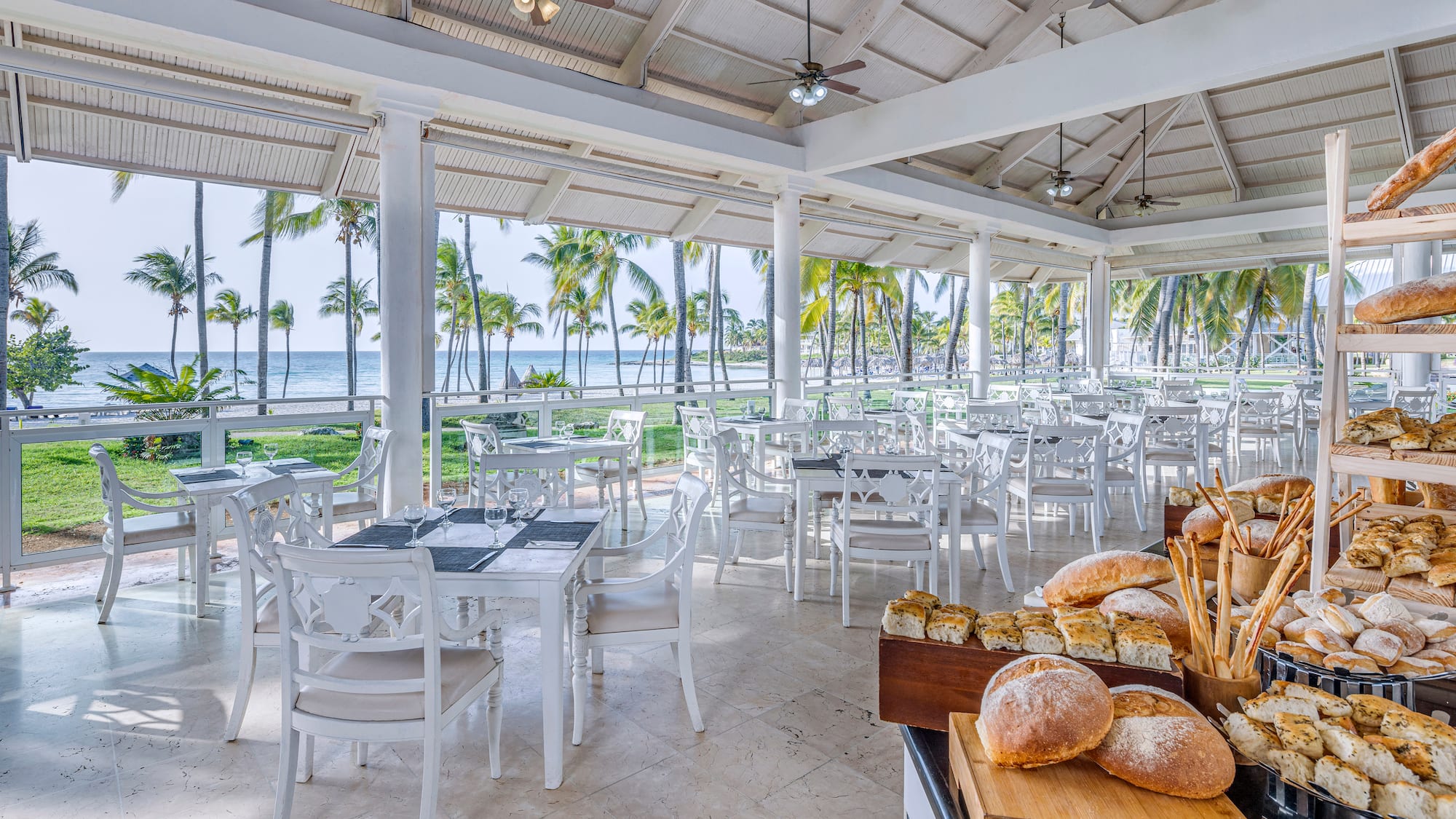 a room with tables and chairs and a table with food on it