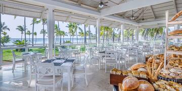 a room with tables and chairs and a table with food on it