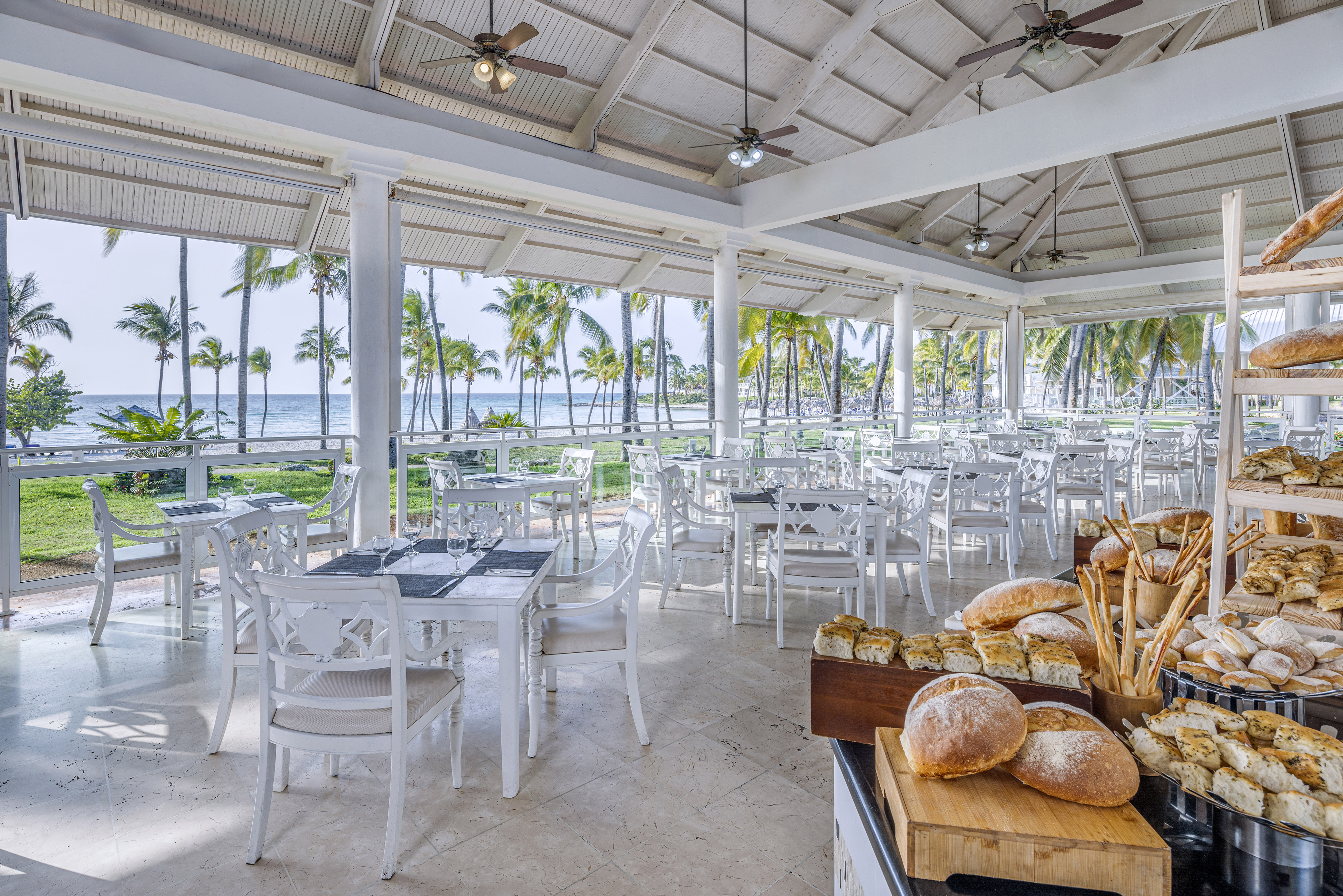 a room with tables and chairs and a table with food on it