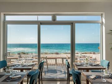 a restaurant with tables and chairs on a beach