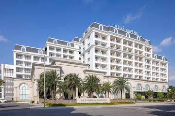 a large white building with palm trees