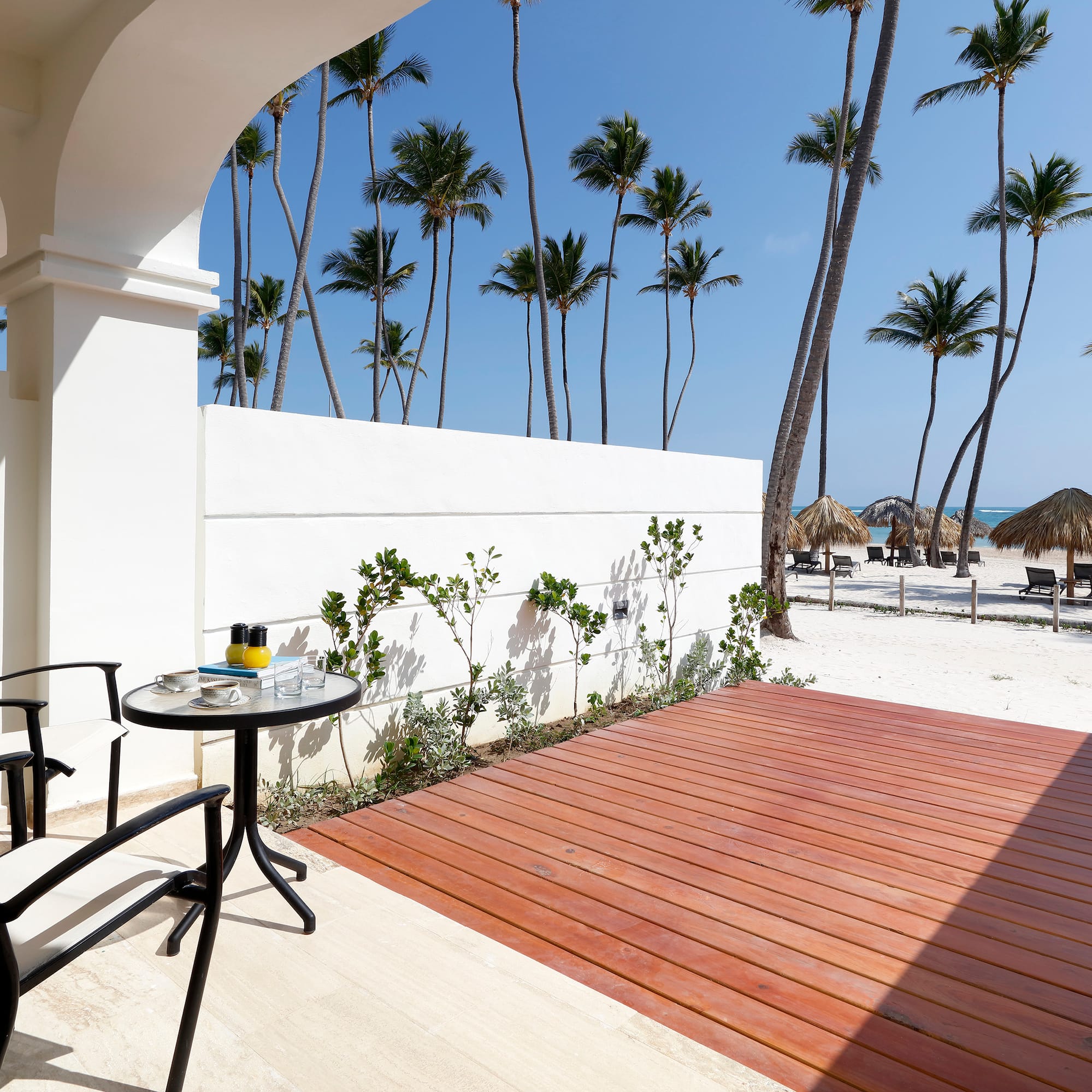a deck with a table and chairs on a beach