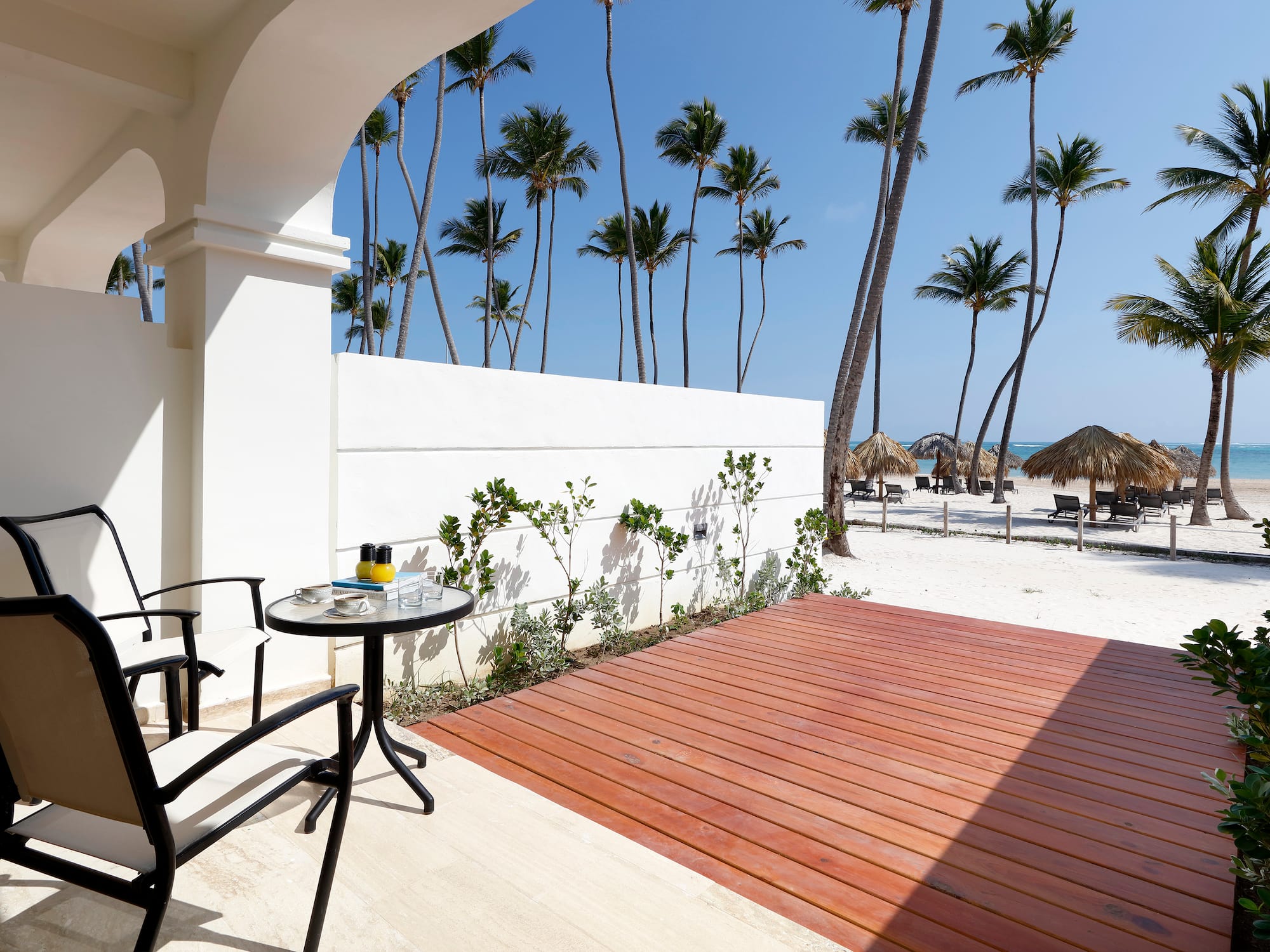 a deck with a table and chairs on a beach