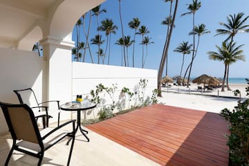 a deck with a table and chairs on a beach