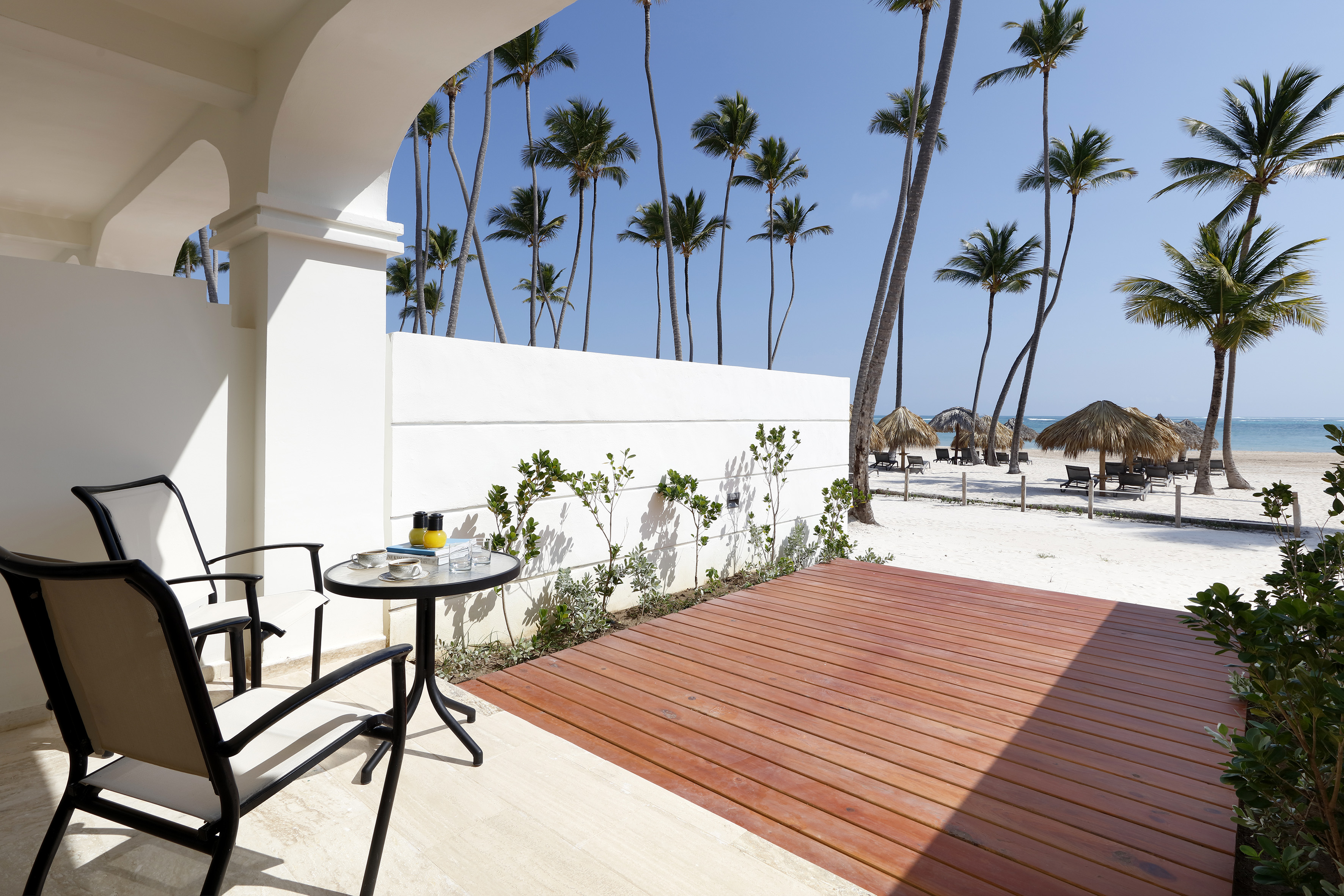 a deck with a table and chairs on a beach