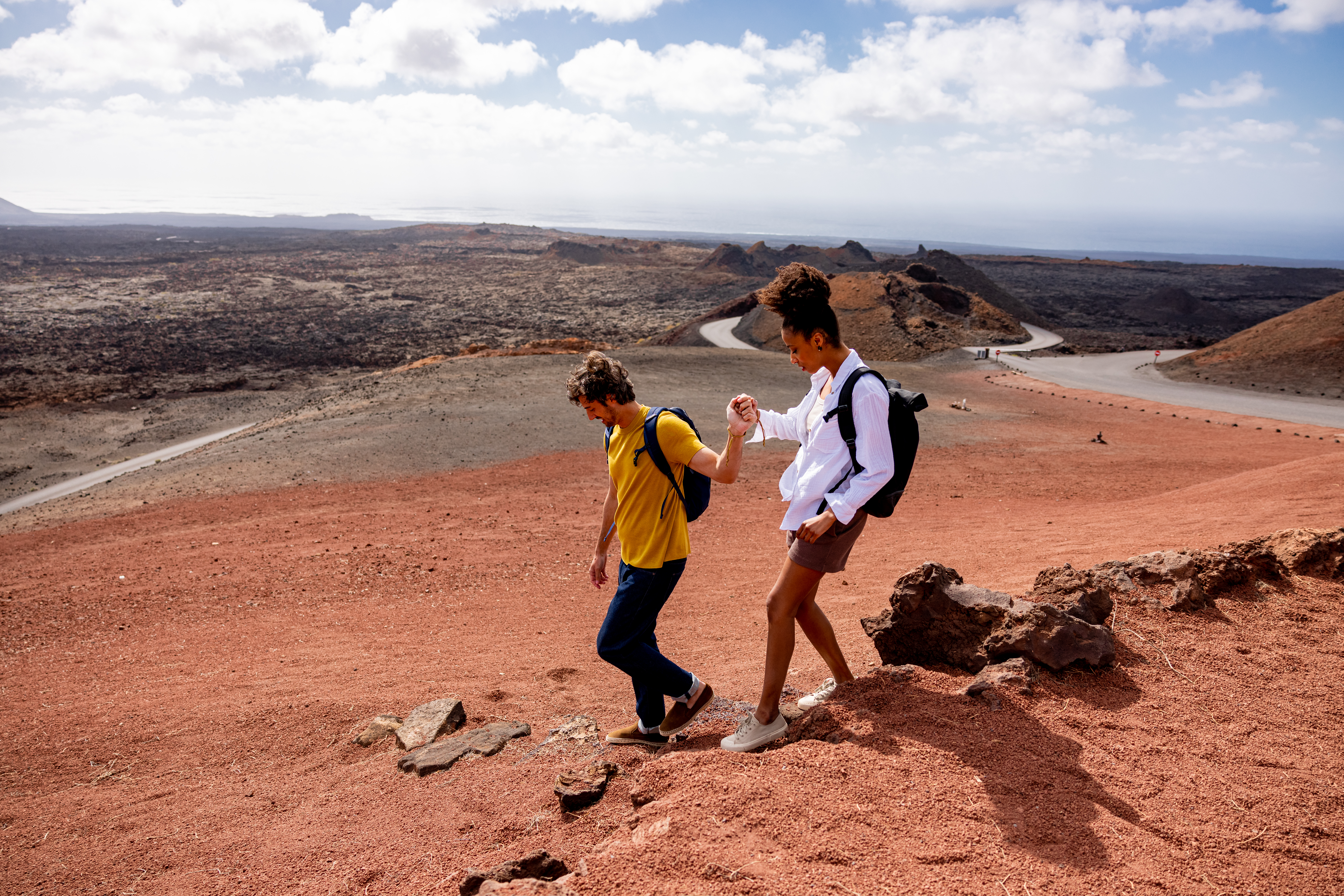 a man and woman walking on a rocky hill