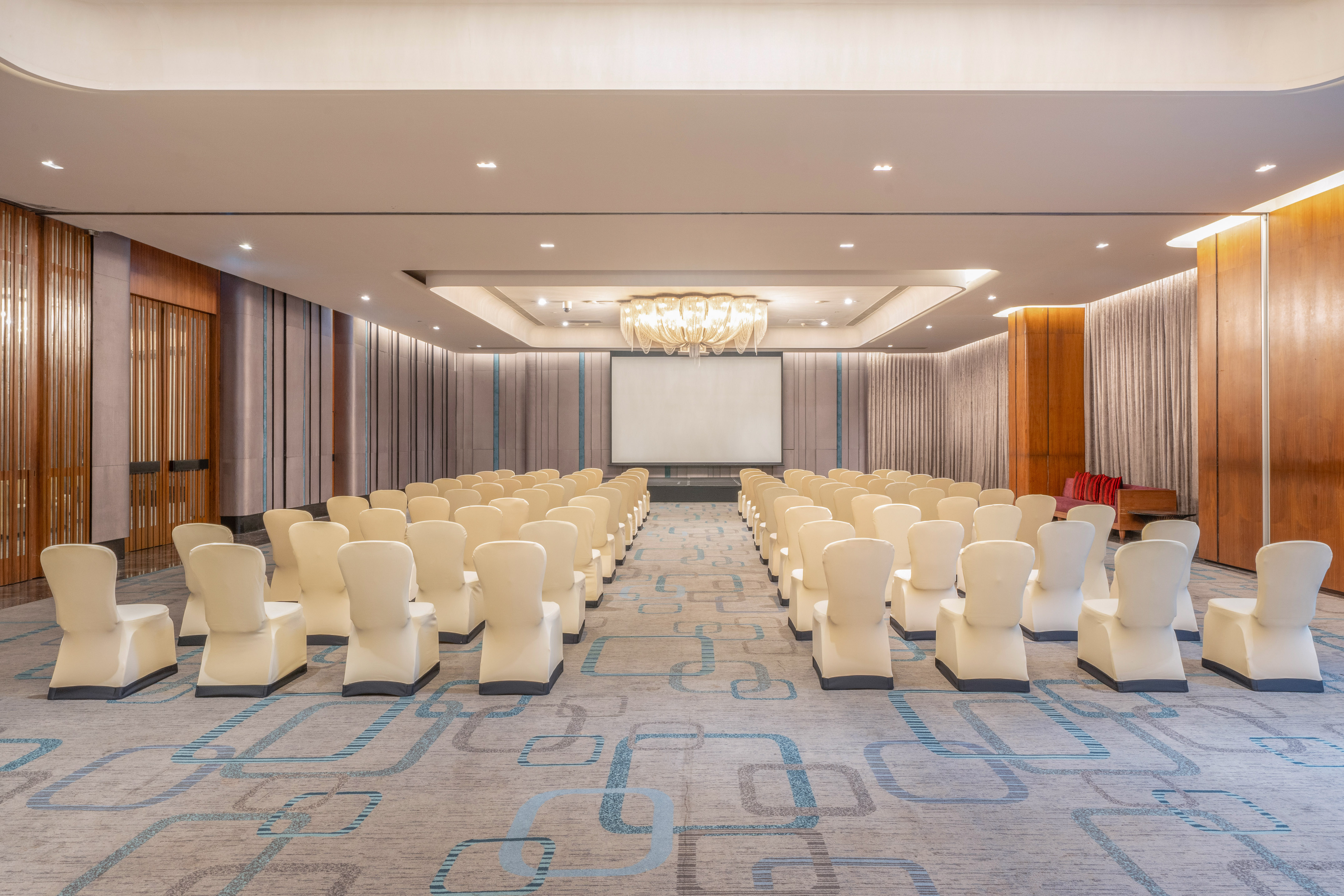 Spacious modern conference hall with rows of chairs facing a projection screen. - Theatre Ballroom - The Hotel Bangkok Sukhumvit 26 Affiliated by Meliá, Bangkok
