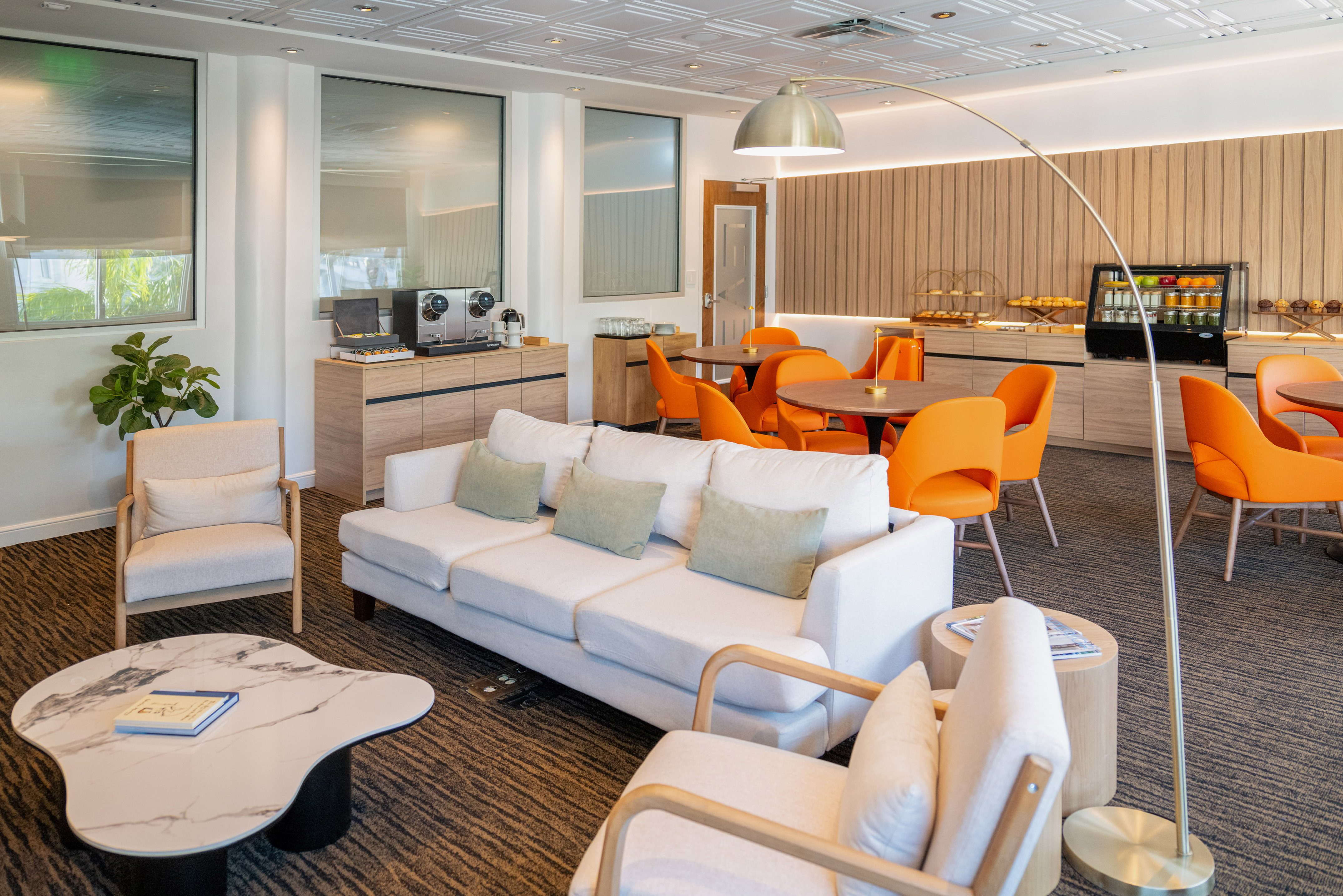 a room with white couches and orange chairs