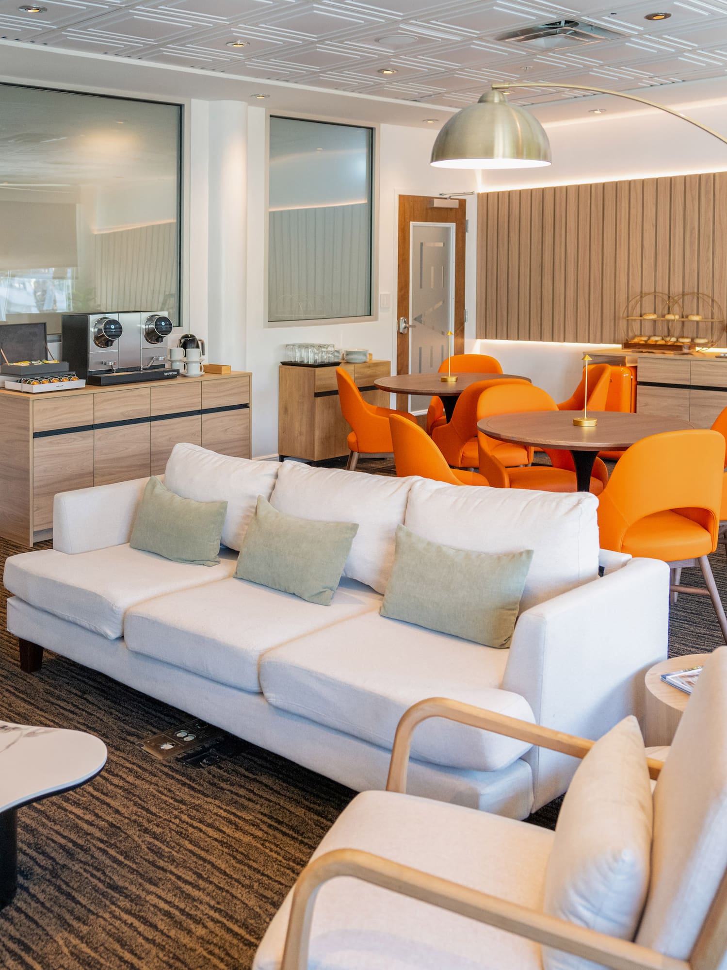a room with white couches and orange chairs