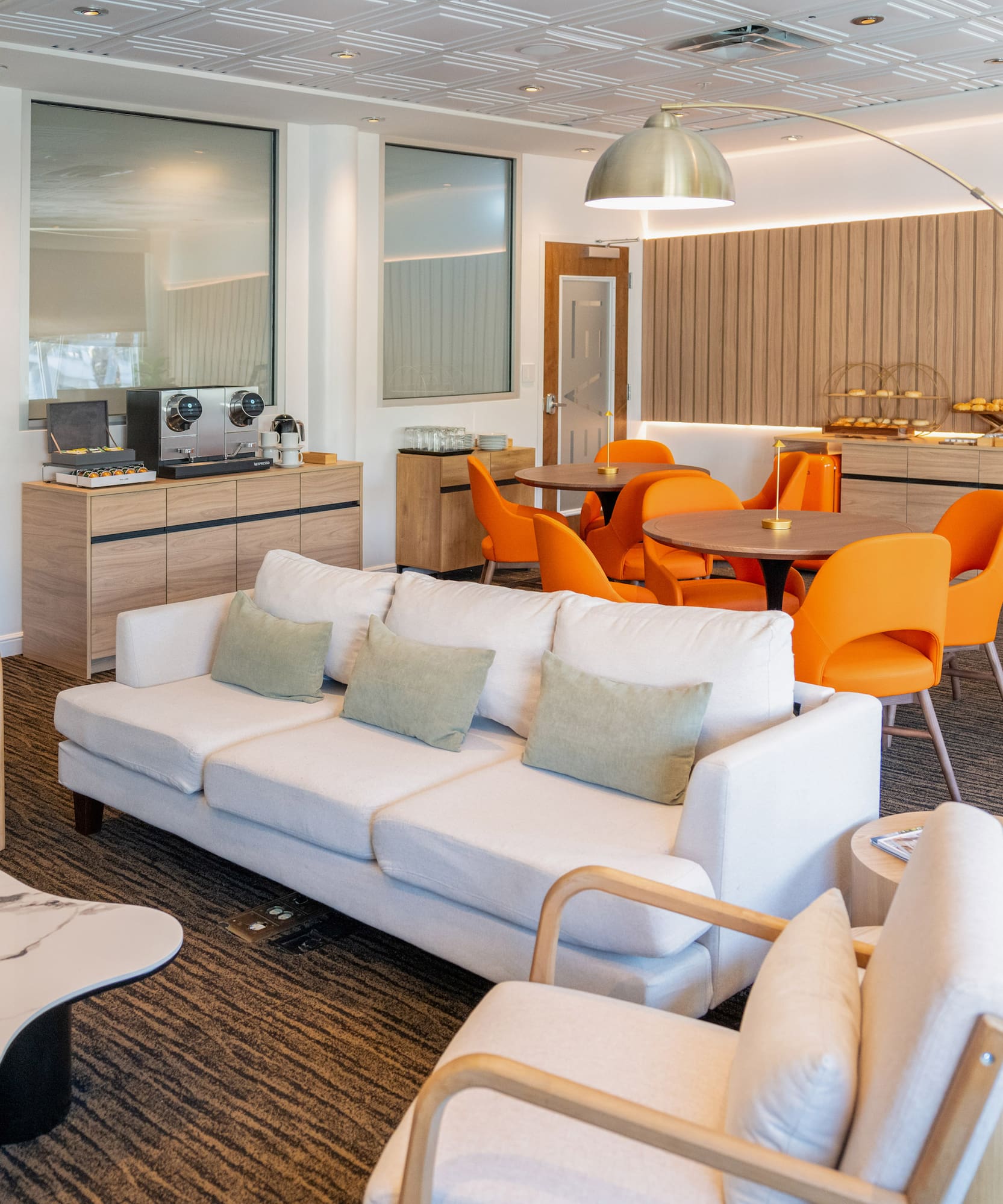 a room with white couches and orange chairs