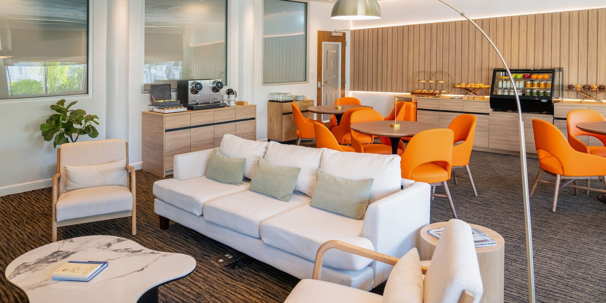 a room with white couches and orange chairs