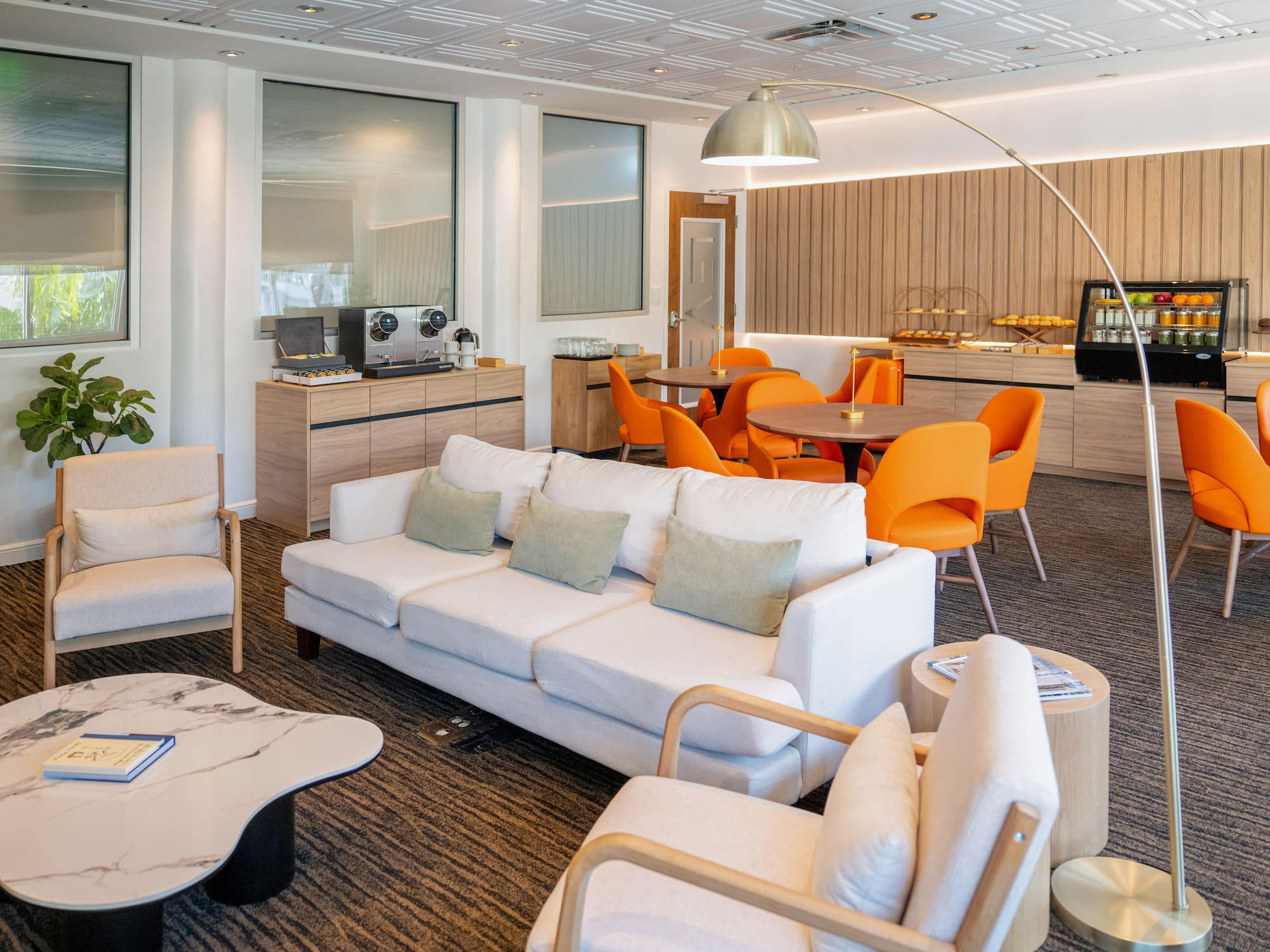 a room with white couches and orange chairs