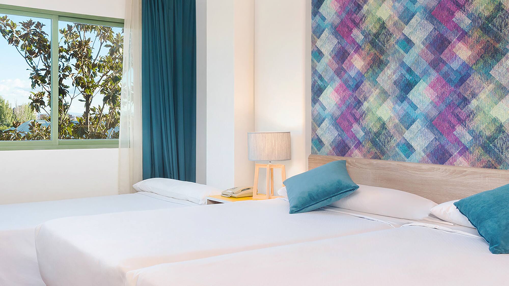 a room with two beds and a colorful wall