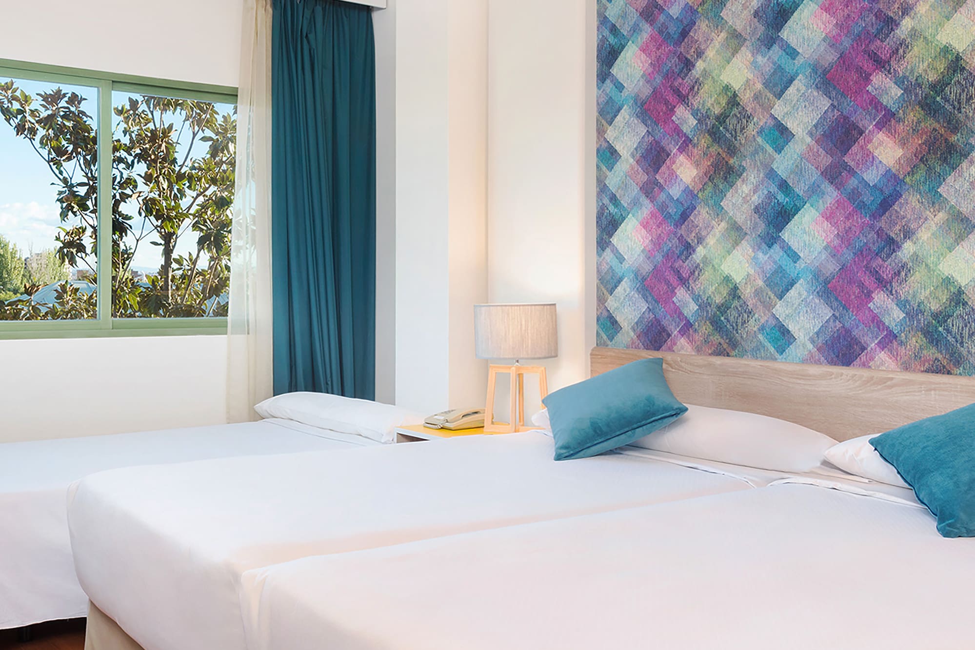 a room with two beds and a colorful wall