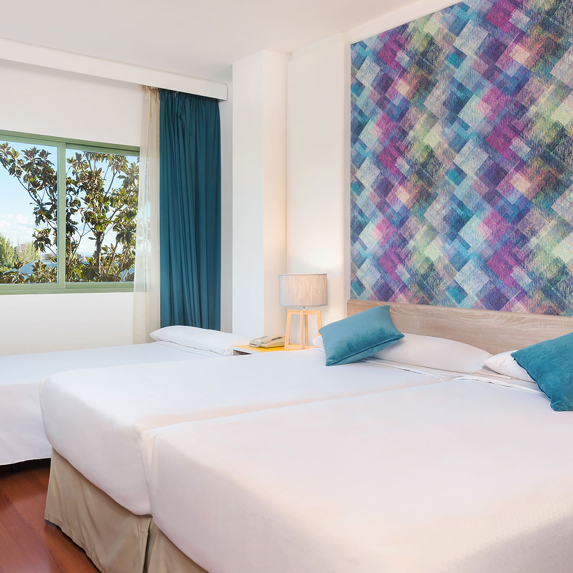 a room with two beds and a colorful wall