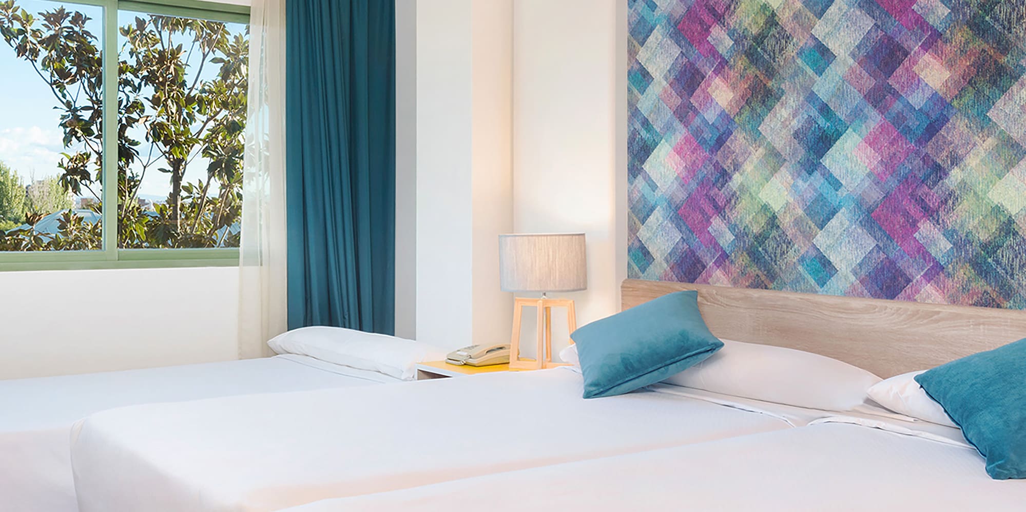 a room with two beds and a colorful wall