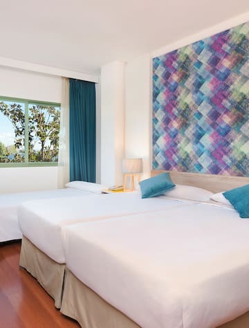 a room with two beds and a colorful wall