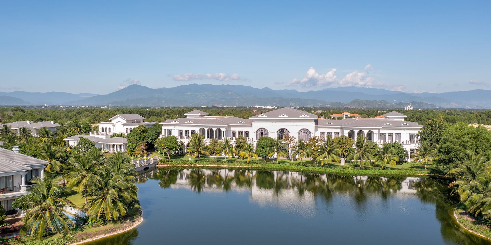 a large white building next to a body of water