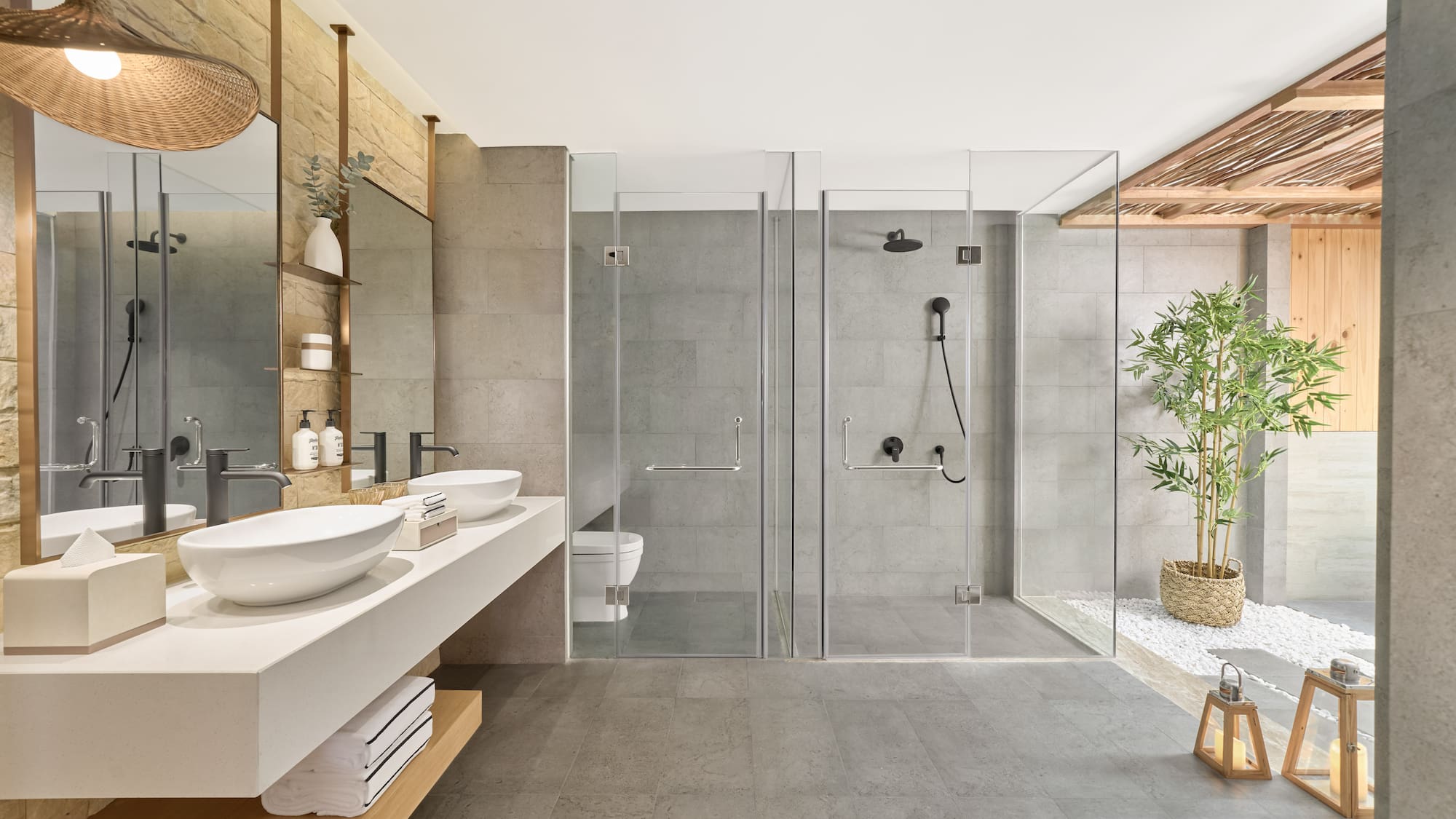 Modern bathroom with dual vanity, glass showers, and spa-like decor.