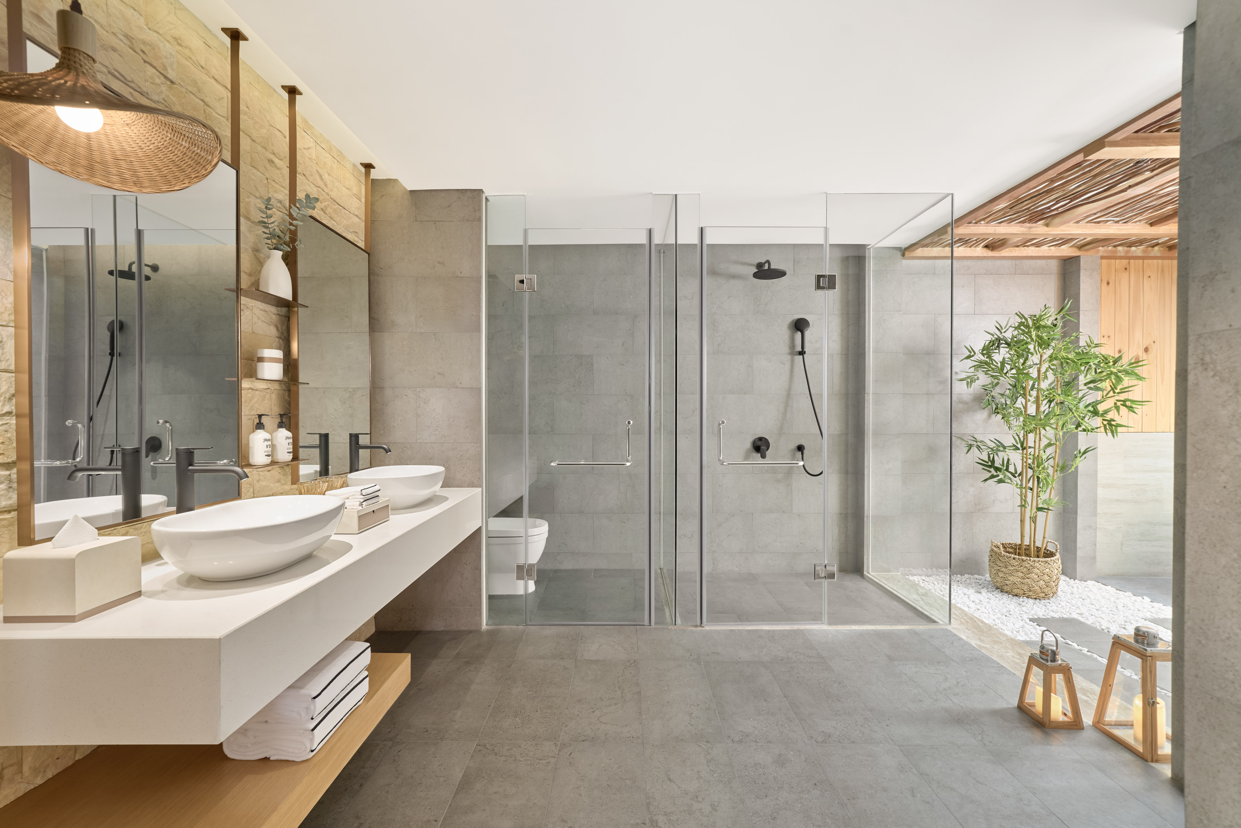 Modern bathroom with dual vanity, glass showers, and spa-like decor.
