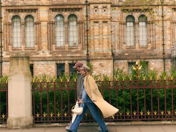 a man and woman walking on a sidewalk