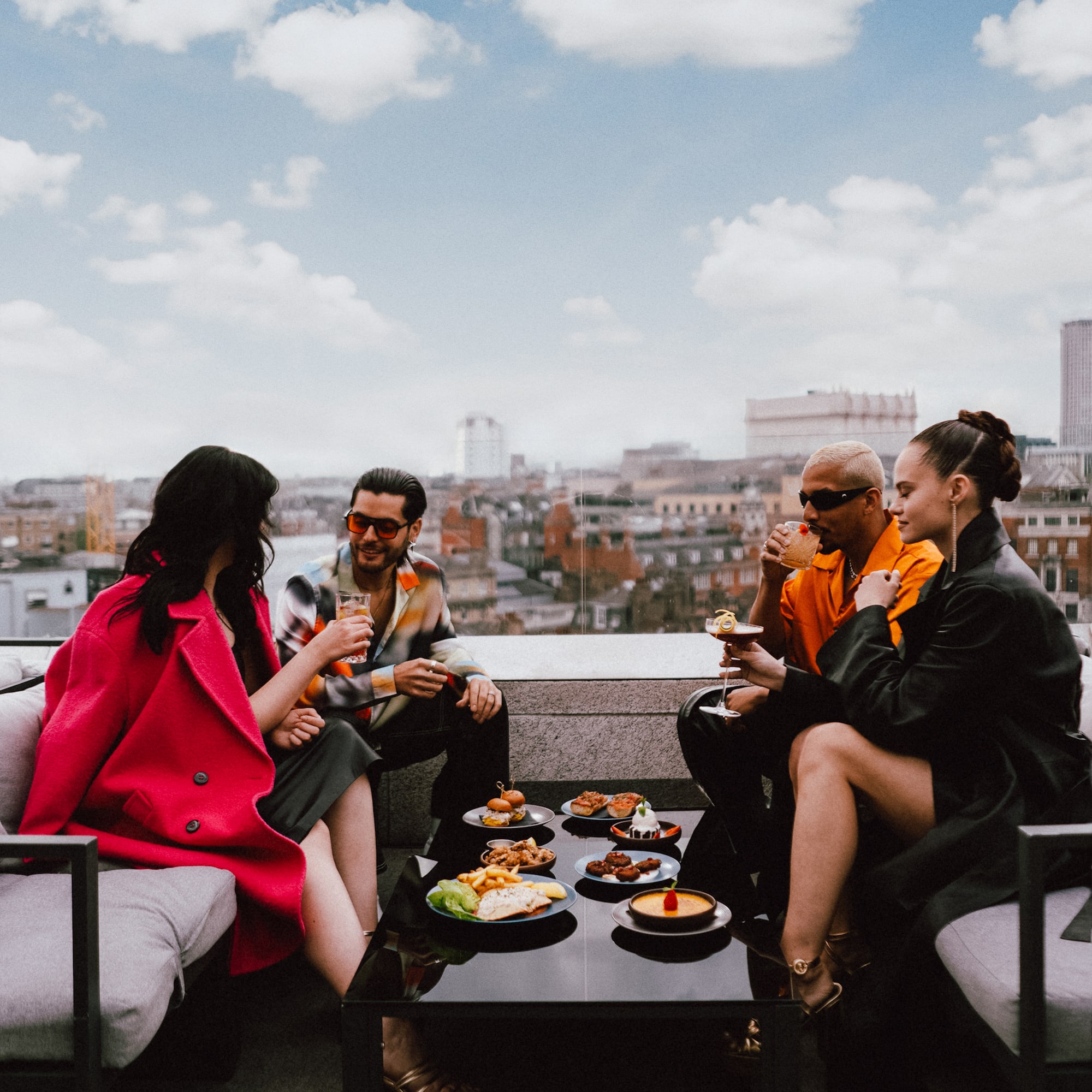 A group of people gathered on a rooftop, enjoying their meal.