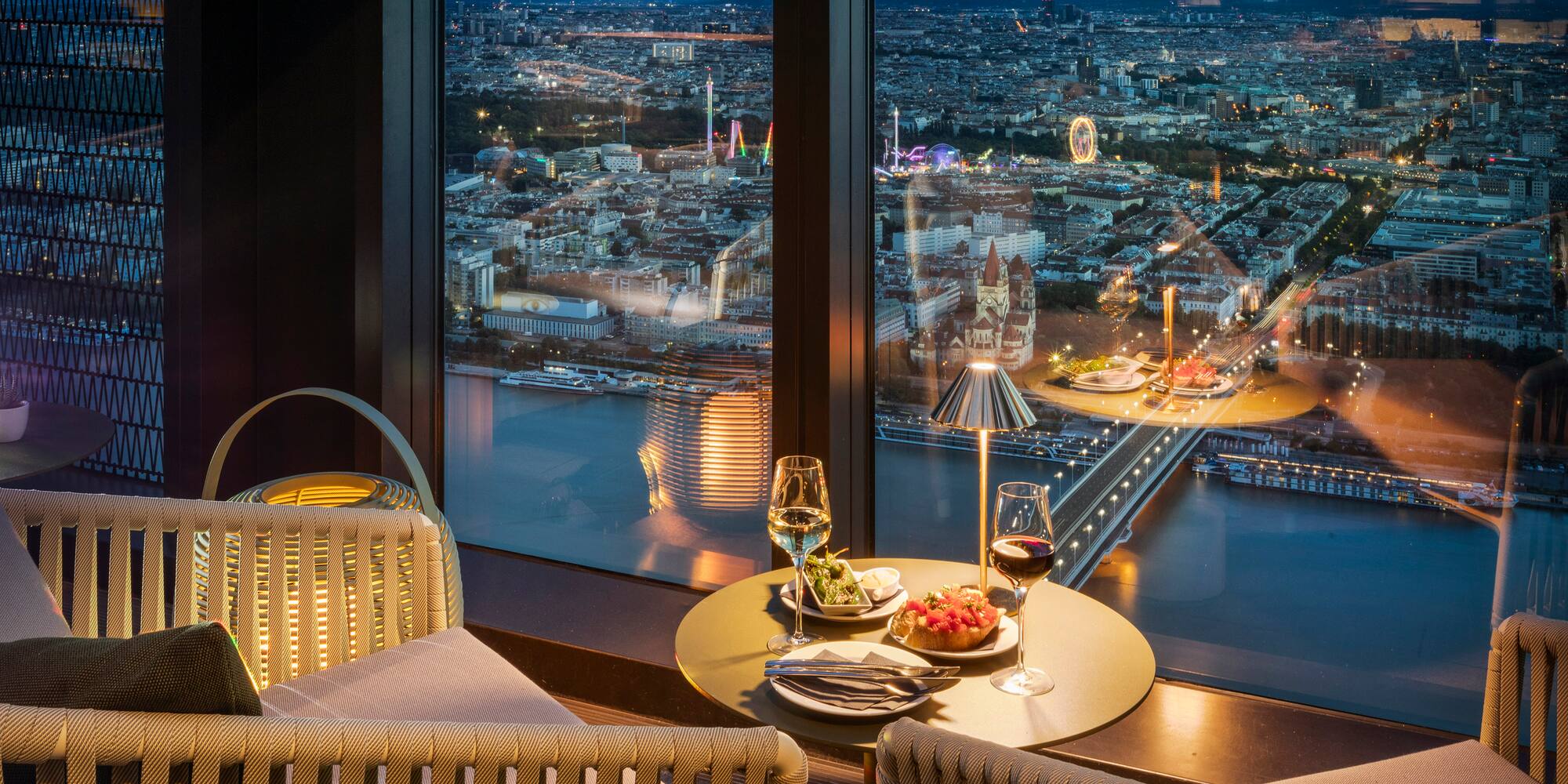 a table with food and wine glasses in front of a window