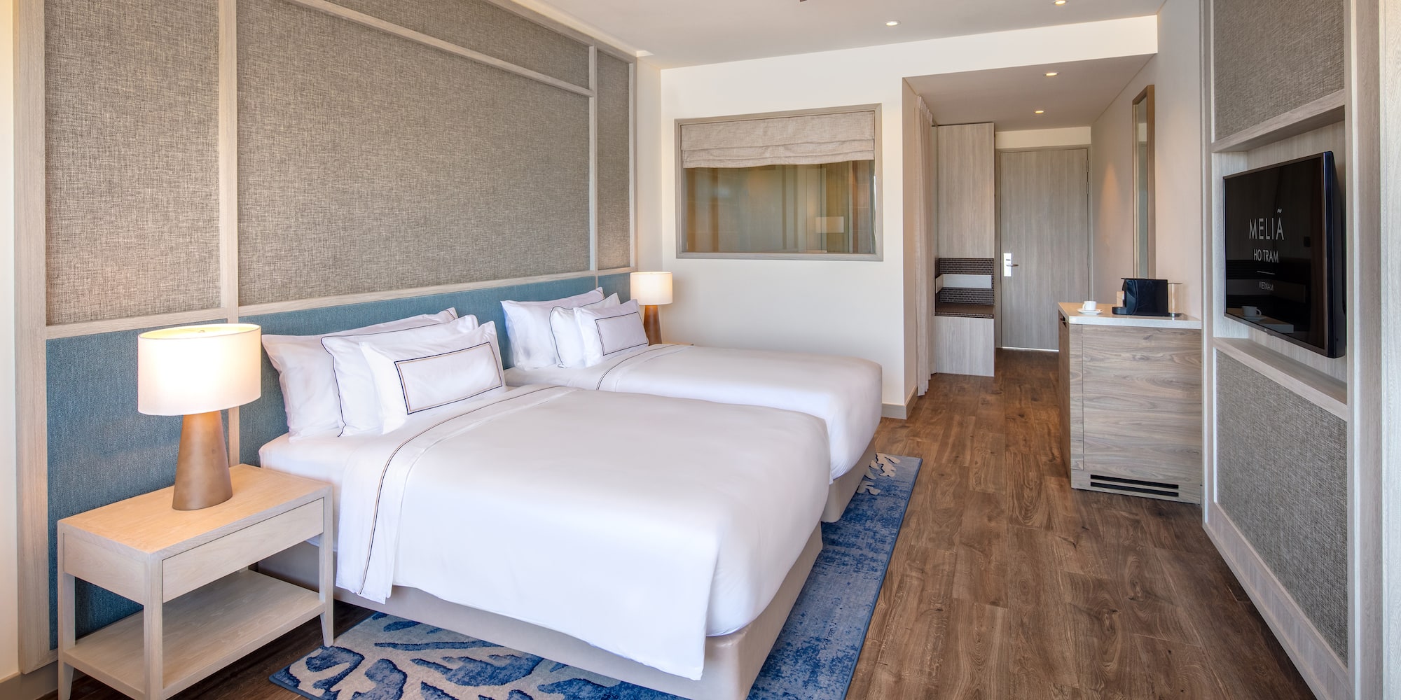 a room with two beds and a ceiling fan