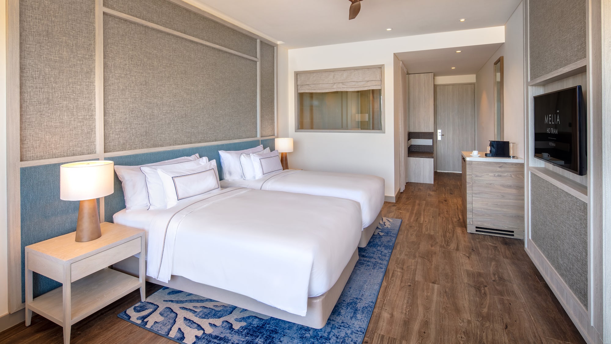 a room with two beds and a ceiling fan